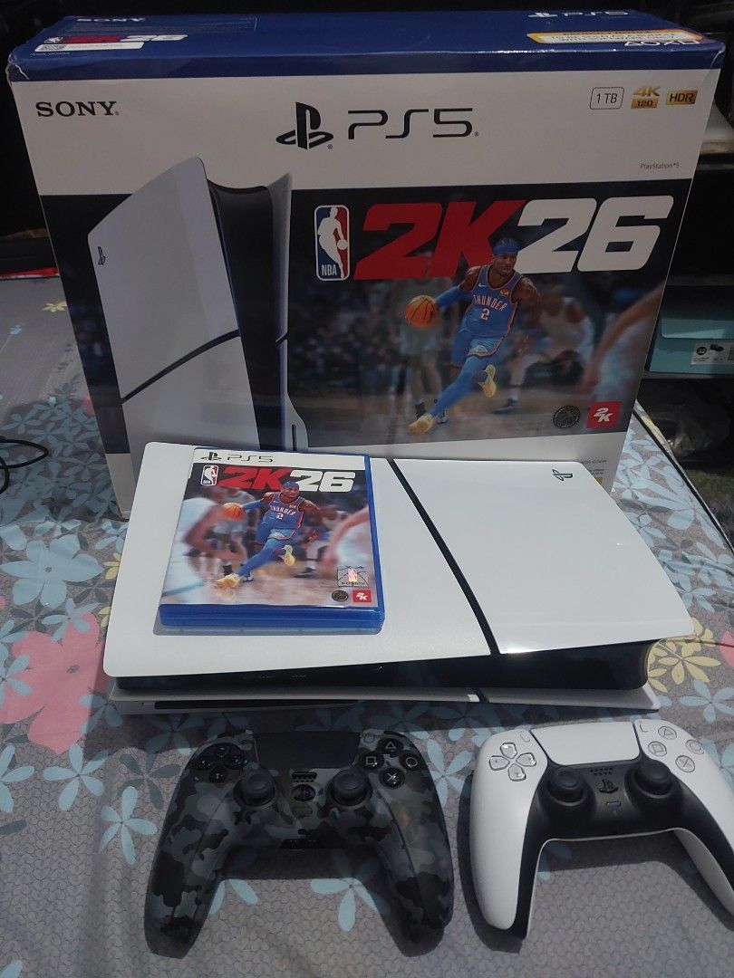 Sony PlayStation 5 Slim Console with NBA 2K26 and 2 Controllers (Category: PlayStation) located in Nasugbu. Submitted by frinceflores (Listing ID 1469609988, Image 1). Description: - PlayStation 5 Slim 1TB Console - NBA 2K26 physical game disc included - Standard white DualSense wireless controller - Extra camo-patterned DualSense controller - Complete with original retail box - Everything in the photos is included.