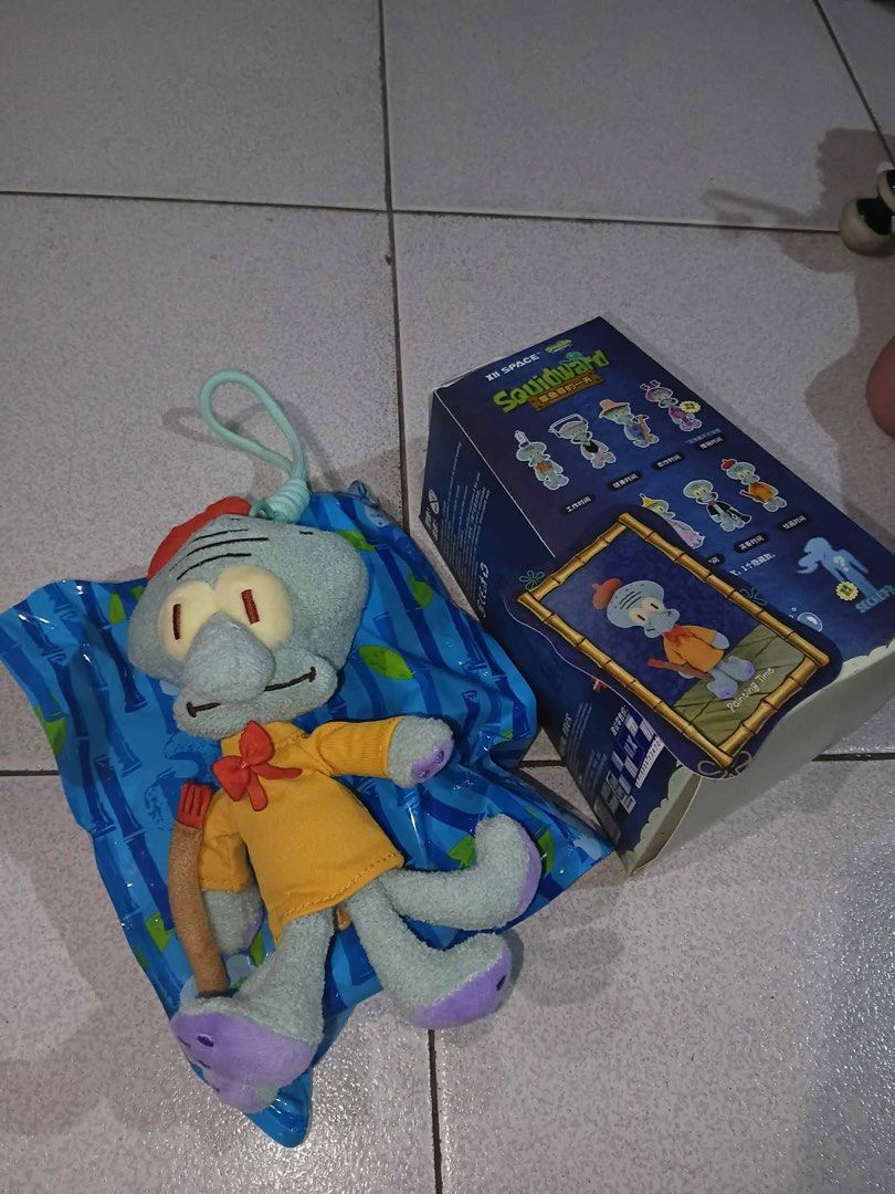 Squidward Painting Time Blind Box Plush Pendant (Category: Plushies & Soft Toys) located in Caloocan City. Submitted by lostrtrp (Listing ID 1469652053, Image 1). Description: - Character: Squidward (Painting Time design from XII Space blind box series) - Outfit/Props: Wearing an orange shirt and holding a paintbrush - Appearance: Mint green plush body with purple feet - Features: Hanging loop attached to the top for easy attachment - Inclusions: