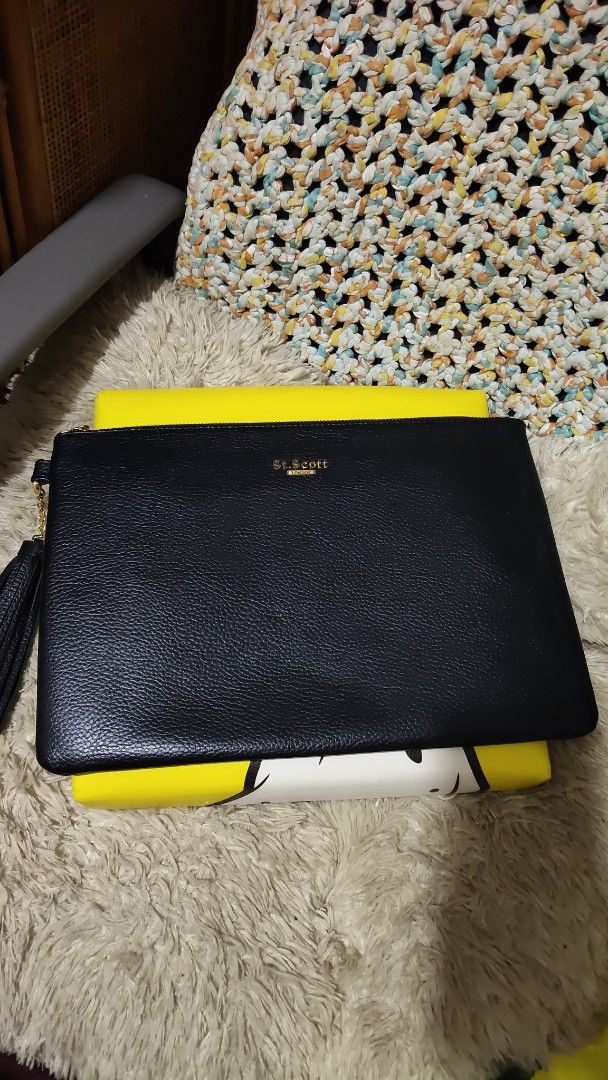 St. Scott London Black Leather Clutch (Category: Clutches) located in Cebu City. Submitted by lumaynojes00490 (Listing ID 1469683385, Image 3). Description: - Brand: St. Scott London - Material: Premium black leather with textured pebble grain finish - Hardware: Elegant gold-tone hardware with stamped gold lettering on the front - Closure: Secure top zip closure with a stylish chained tassel zipper pull - Capacity: Practical daily size, fits your