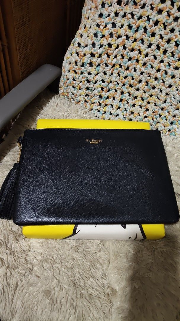 St. Scott London Black Leather Clutch (Category: Clutches) located in Cebu City. Submitted by lumaynojes00490 (Listing ID 1469683385, Image 1). Description: - Brand: St. Scott London - Material: Premium black leather with textured pebble grain finish - Hardware: Elegant gold-tone hardware with stamped gold lettering on the front - Closure: Secure top zip closure with a stylish chained tassel zipper pull - Capacity: Practical daily size, fits your