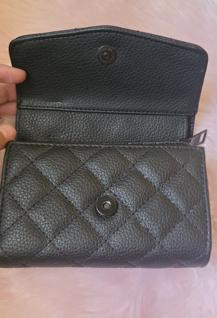 Steve Madden Black Quilted Wallet (Category: Wallets & Card holders) located in Amadeo. Submitted by riccchfinds (Listing ID 1469648107, Image 3). Description: - Brand: Steve Madden - Color: Classic Black with chic quilted texture - Material: Durable pebble-grain synthetic leather - Closure: Fold-over flap with secure magnetic snap button - Interior Features: Multiple card slots, clear ID window, and cash compartments - Condition: Clean inside an
