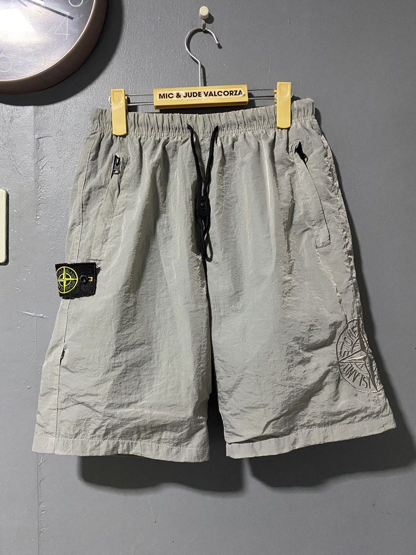 Stone Island nylon metal grey shorts with compass patch (Category: Shorts) located in Tanay. Submitted by judevalcorza (Listing ID 1469707315, Image 1). Description: - Stone Island grey nylon shorts - Lightweight, crinkled fabric ideal for warm weather - Comfortable elastic waistband with adjustable drawstring - Two secure zipped front pockets and one back pocket - Signature removable compass badge on right leg - Large embroidered compass logo gr