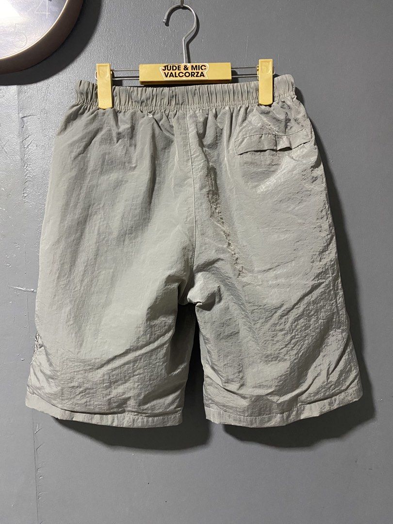 Stone Island nylon metal grey shorts with compass patch (Category: Shorts) located in Tanay. Submitted by judevalcorza (Listing ID 1469707315, Image 2). Description: - Stone Island grey nylon shorts - Lightweight, crinkled fabric ideal for warm weather - Comfortable elastic waistband with adjustable drawstring - Two secure zipped front pockets and one back pocket - Signature removable compass badge on right leg - Large embroidered compass logo gr