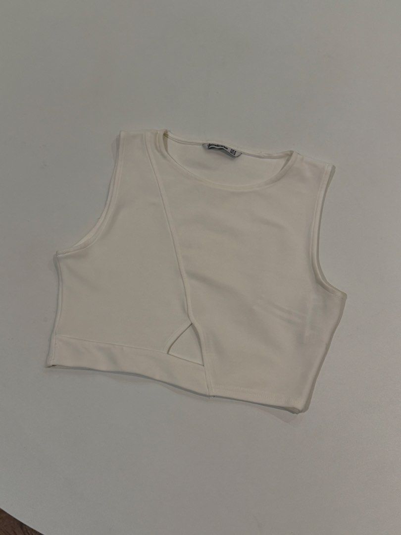 Stradivarius White Cutout Crop Top Size M (Category: Sleeveless) located in Muntinlupa City. Submitted by henlo03 (Listing ID 1469611364, Image 1). Description: - Brand: Stradivarius - Size: EUR M / USA M / MEX 28 - Color: Classic White - Style: Sleeveless crop top with round neckline and relaxed fit - Detail: Trendy asymmetric cutout near the front hem - Back: Plain and simple - Condition: like new.