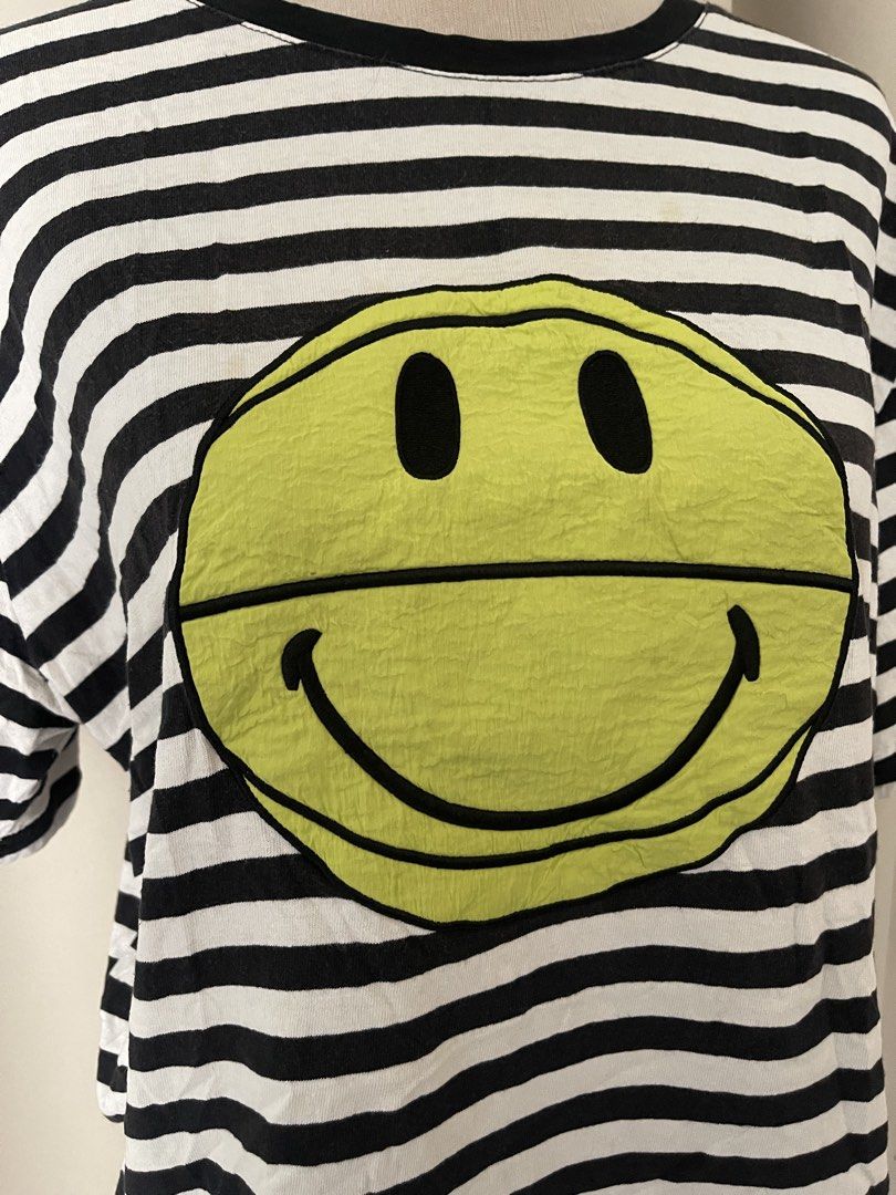 Striped embroid smiley (Category: Shirts) located in Cainta. Submitted by zlove111 (Listing ID 1469619528, Image 3). Description: - Style: Casual oversized tee - Design: Classic black and white stripes with a bold neon yellow smiley face graphic - Details: Round collar, short sleeves, and a brand fabric tag near the bottom hem - Fit: Super comfy and relaxed - Condition: Brand new / Excellent quality - Shipping: Ships fast via J&T mop gcsh no issu