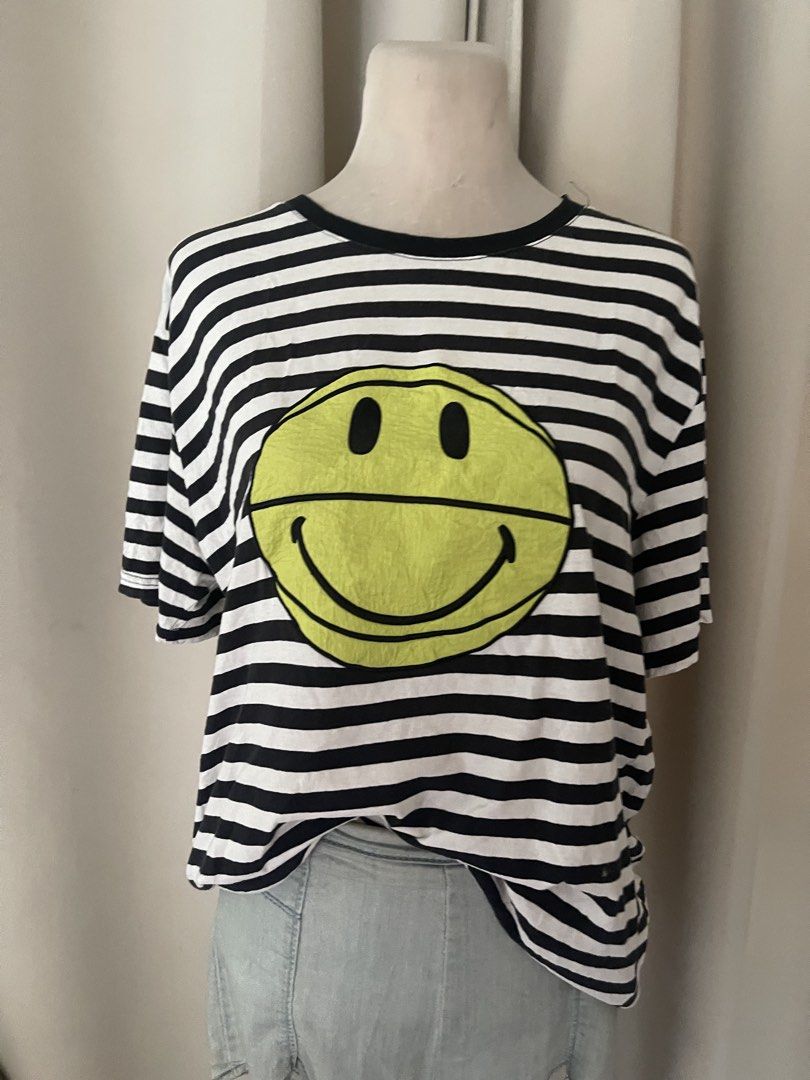 Striped embroid smiley (Category: Shirts) located in Cainta. Submitted by zlove111 (Listing ID 1469619528, Image 2). Description: - Style: Casual oversized tee - Design: Classic black and white stripes with a bold neon yellow smiley face graphic - Details: Round collar, short sleeves, and a brand fabric tag near the bottom hem - Fit: Super comfy and relaxed - Condition: Brand new / Excellent quality - Shipping: Ships fast via J&T mop gcsh no issu