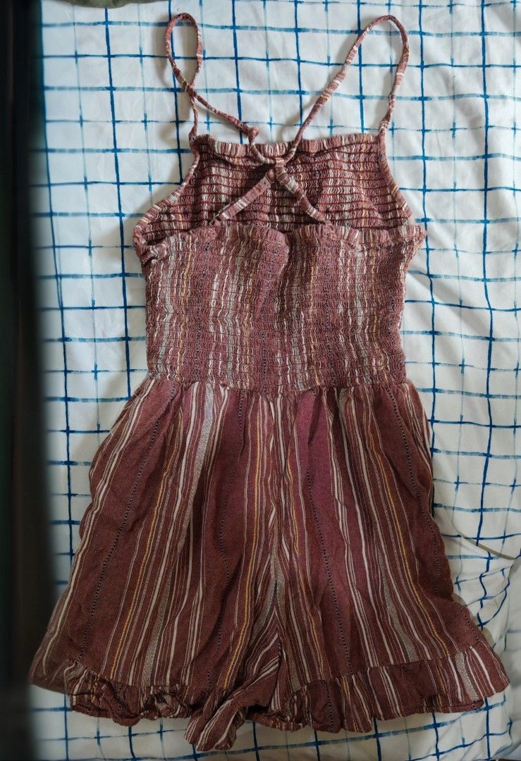 Striped Smocked Romper with Ruffle Hem (Category: Rompers) located in Paranaque City. Submitted by MLandCobyApple (Listing ID 1469626671, Image 2). Description: - Color/Pattern: Brown with white, yellow, and green vertical stripes - Top: Stretchy smocked bodice with crisscross spaghetti straps in the back - Bottom: Shorts with a cute ruffle trim along the hem - Material: Lightweight and breezy fabric, ideal for hot days - Condition: Brand new / E