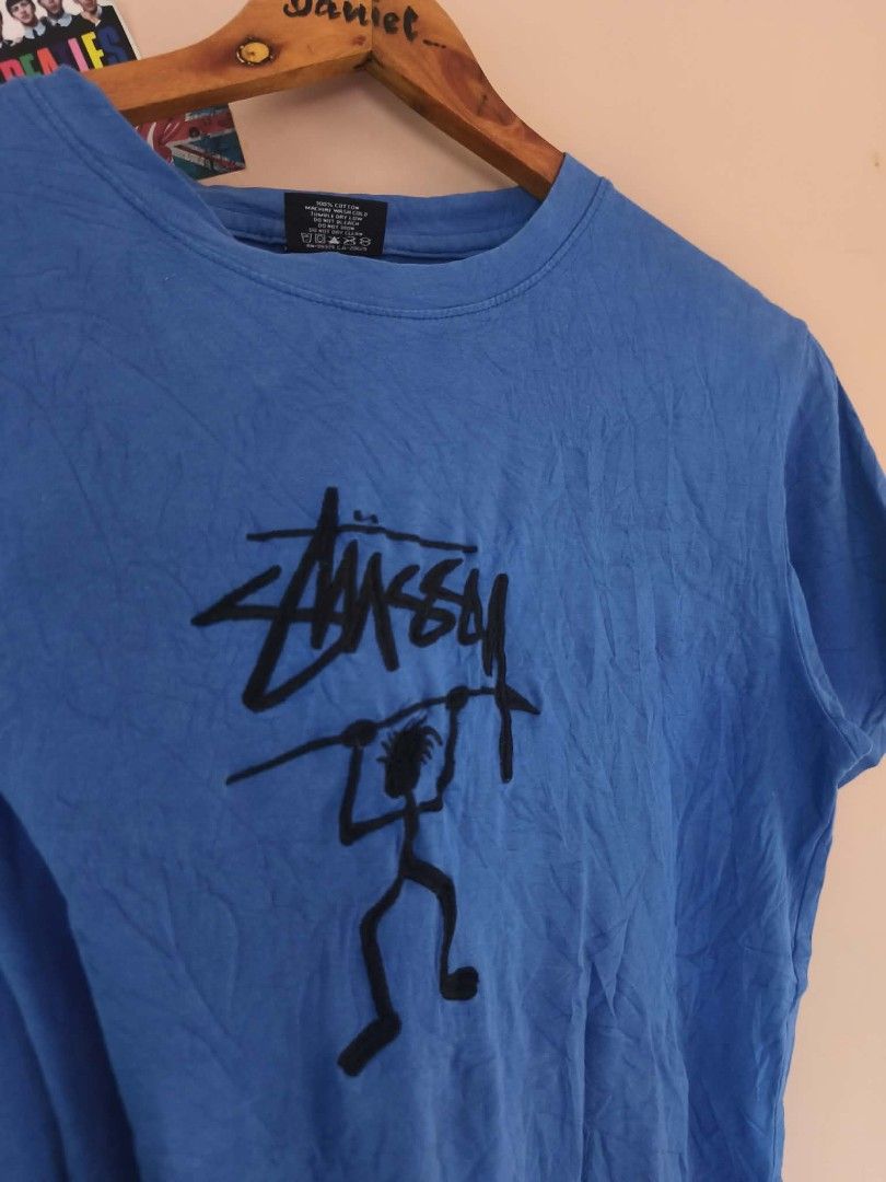 Stüssy Blue Graphic T-shirt (Category: Tshirts & Polo Shirts ) located in Manila. Submitted by cookthrift (Listing ID 1469576448, Image 2). Description: - Brand: Stüssy - Color: Blue with black front graphic - Material: 100% cotton (Made in Mexico) - Fit: Regular fit, crew neck, short sleeves - Details: Includes inner washing tag and white frayed bottom side tag - Condition: Excellent streetwear staple, ready to wear - Shipping: Ships via J&T Exp