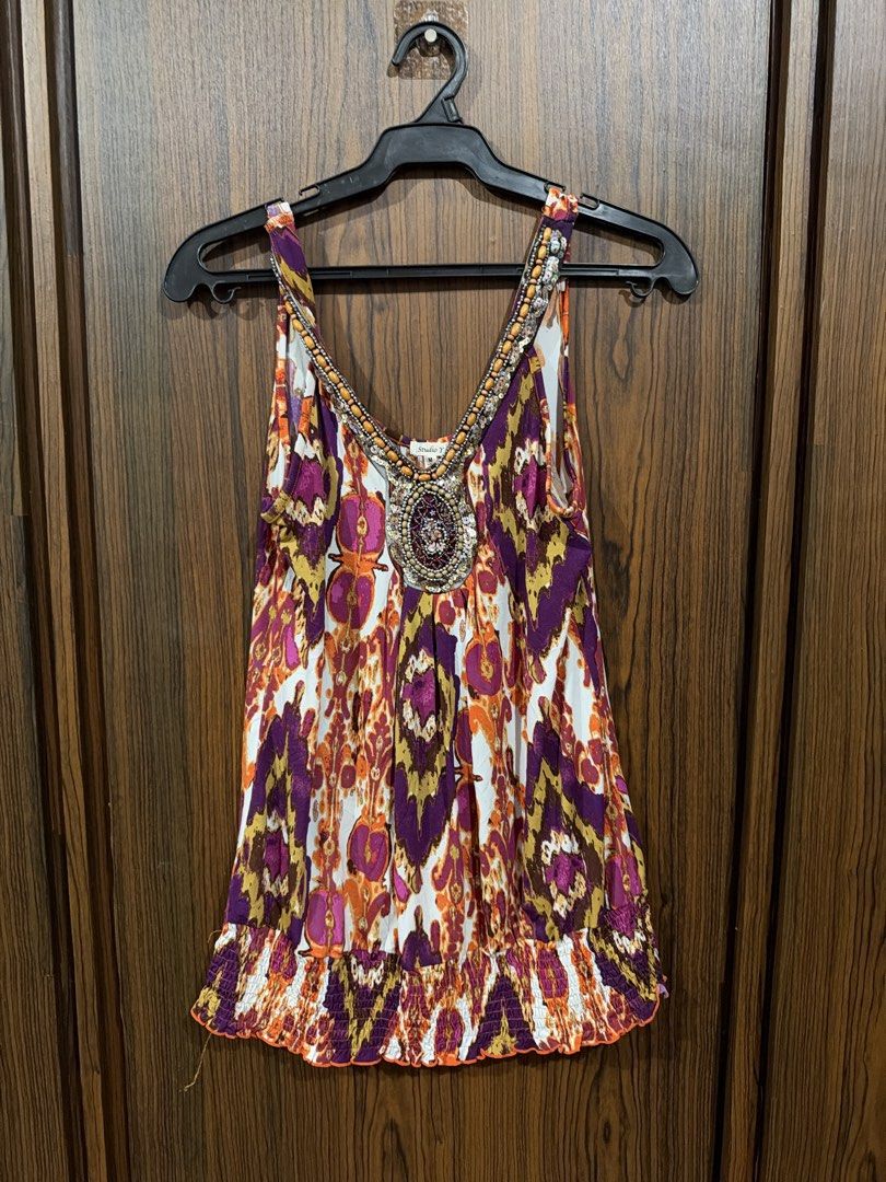 Studio Y Purple Patterned Beaded V-Neck Tank Top (Category: Sleeveless) located in Quezon City. Submitted by co.coph (Listing ID 1469701398, Image 1). Description: - Brand: Studio Y - Size: M (tag at inner collar) - Design: Intricate pattern in vibrant purple, orange, and yellow - Details: Eye-catching, heavily beaded V-neckline with decorative stones - Fit: Smocked elastic hem at the bottom for a flattering, fitted silhouette - Fabric: Lightweig