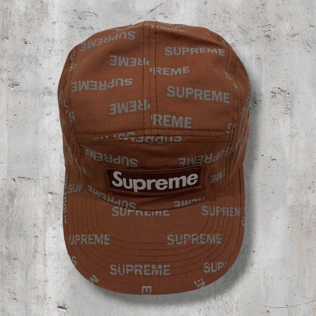 Supreme Brown Repeater Camp Cap (Category: Caps & Hats) located in Iloilo. Submitted by lowesdrift (Listing ID 1469626857, Image 1). Description: - Brand: Supreme - Style: 5-panel camp cap - Color: Brownish-orange with all-over reflective text print - Details: Iconic box logo stitched on the front, clean interior with black inner taping - Fit: Adjustable strap closure in the back - Origin: Made in USA with imported materials - Condition: Excellen