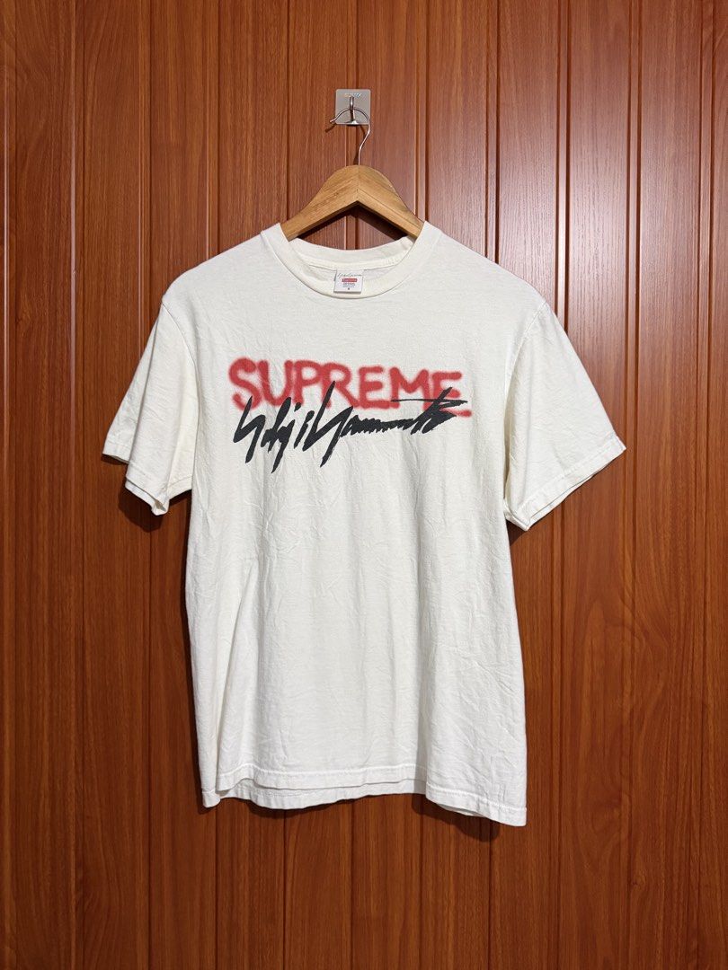 Supreme x Yohji Yamamoto White Tee (Category: Tshirts & Polo Shirts ) located in Manila. Submitted by tlfph (Listing ID 1469690873, Image 1). Description: - Brand: Supreme x Yohji Yamamoto - Size: Small - Color: White - Material: 100% pre-shrunk cotton (Made in U.S.A.) - Design: Red spray paint Supreme logo with black signature print - Condition: Clean fabric, crisp and clear graphics - Care: Machine wash warm.