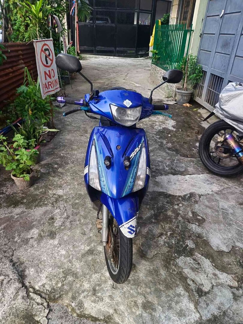 Suzuki Step 125 Blue Scooter Motorcycle (Category: Motorbikes for Sale) located in Valenzuela. Submitted by archie.rivera04-40444 (Listing ID 1469590508, Image 2). Description: Suzuki Step 125 automatic scooter, bright blue body panels with white accent graphics. Black vinyl seat. Spoke wheels with front disc brake. Kickstand and center stand installed. Handlebars fitted with custom grips and levers. Standard floorboard and exhaust pipe. Normal w