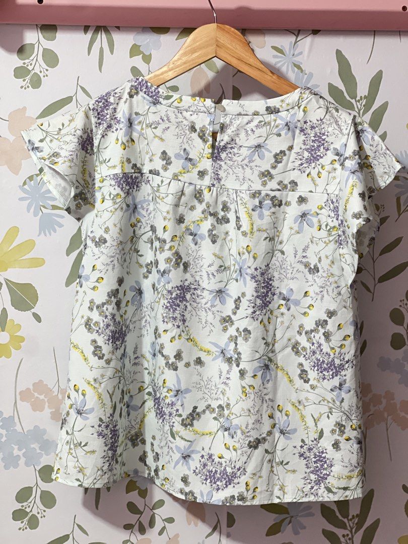 Te chichi Floral Print Blouse Size M (Category: Blouses) located in Pasig City. Submitted by morilove (Listing ID 1469585591, Image 3). Description: - Brand: Te chichi (Japanese Brand) - Style: Floral blouse with short flutter sleeves and round neckline - Color/Pattern: Light blue base with purple and grey floral print - Size: Medium (M) - Material: 100% polyester (lightweight and comfortable) - Features: Back button closure, gathered yoke detail