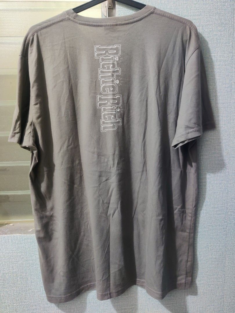 Richie Rich Graphic T-Shirt (Category: Tshirts & Polo Shirts ) located in Pasig City. Submitted by shiyenaaa (Listing ID 1469669792, Image 2). Description: - Brand/Collab: Tee Culture x Richie Rich - Color: Grey - Size: 2XL (Relaxed Fit) - Material: 100% Cotton - Design: Large comic graphic on the front, vertical Richie Rich lettering and diamond graphics on the back - Condition: Excellent / As described.