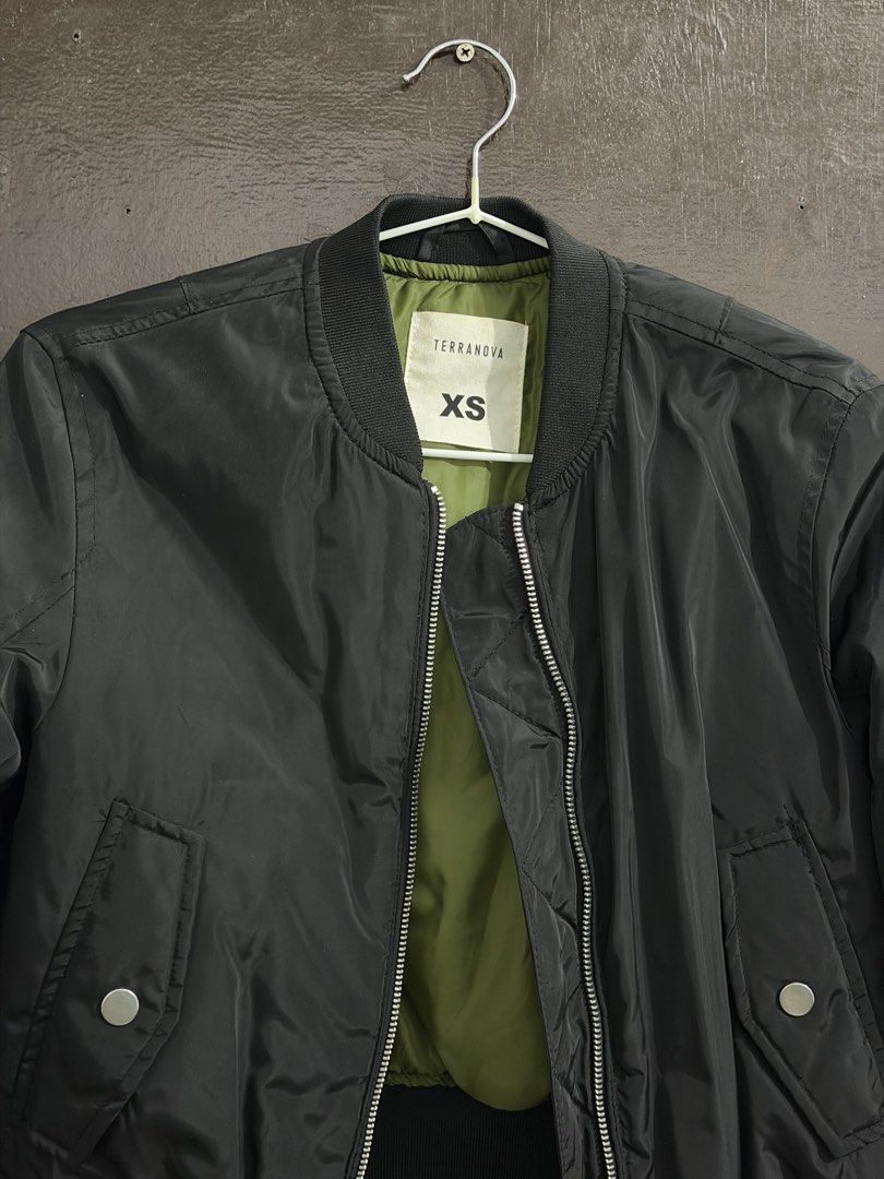 Terranova Black Bomber Jacket Size XS (Category: Coats, Jackets and Outerwear) located in Manila. Submitted by meeyaw23 (Listing ID 1469653998, Image 2). Description: - Brand: Terranova - Color: Black with olive green inner lining - Size: XS - Closure: Zip-up front with silver hardware - Pockets: Front snap-button pockets and sleeve zip pocket - Details: Ribbed collar, cuffs, and hem - Fit: Casual, great layer for cooler weather.