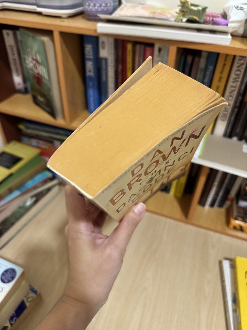 The Da Vinci Code by Dan Brown paperback (Category: Storybooks) located in Quezon City. Submitted by mm_dxm (Listing ID 1469590360, Image 2). Description: - Title: The Da Vinci Code by Dan Brown - Format: Paperback - Condition: Pre-loved with yellowed pages from age and slight cover edge curling; spine and pages fully intact - Genre: Bestselling mystery and suspense thriller - Perfect addition to any bookshelf for fiction lovers.