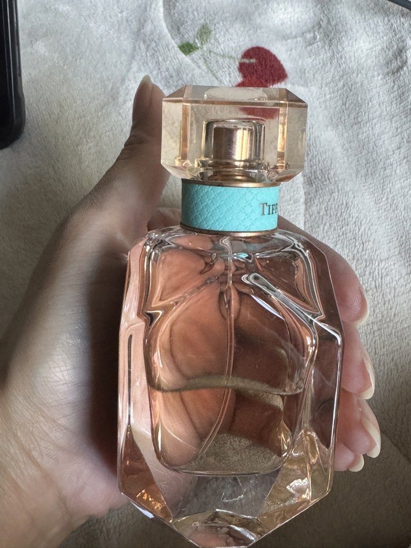 Tiffany & Co. Rose Gold Eau de Parfum (Category: Fragrance & Deodorants) located in Manila. Submitted by ohashelee (Listing ID 1469638011, Image 3). Description: - Authentic Tiffany & Co. Rose Gold fragrance - Volume: Around half full (pinkish liquid visible in clear glass) - Scent Notes: Black currant, blue rose, and ambrette seed - Packaging: Faceted glass bottle with signature teal collar - Reason for selling: Vanity decluttering - Ships secur