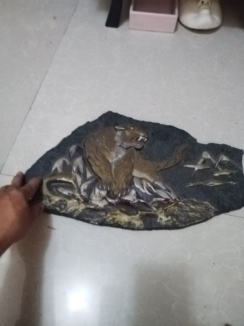 Tiger on rocky (Category: Vintage Collectibles) located in San Rafael. Submitted by jflshoppe1989 (Listing ID 1469630341, Image 2). Description: Key Features • Design: A three-dimensional or raised (relief) sculpture of a roaring tiger set against a natural stone or slate background. • Material: Natural stone, slate, or composite stone plaque with metallic or painted accent details. • Purpose: Commonly used as an interior decoration or an auspici