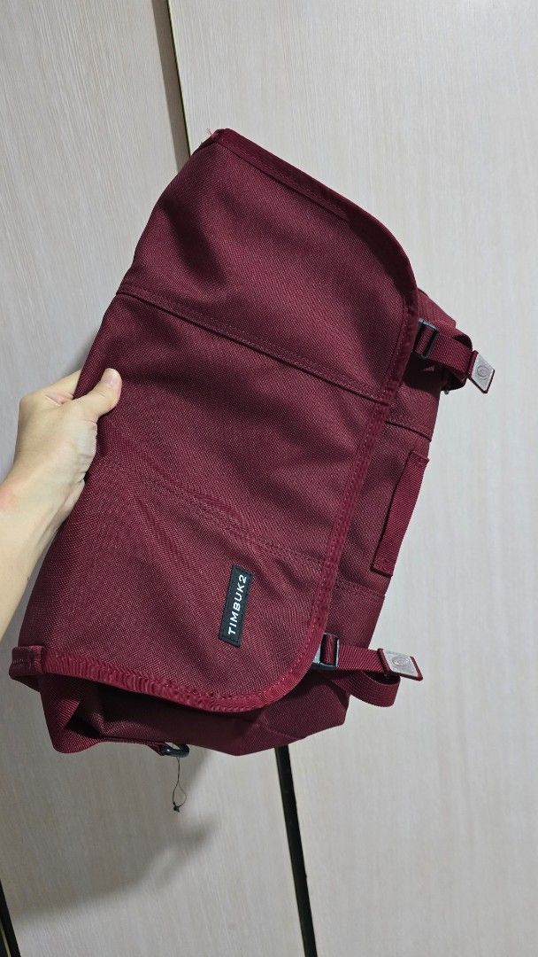 Timbuk2 Maroon Messenger Bag (Category: Sling Bags) located in Pasig City. Submitted by spaceshift (Listing ID 1469710725, Image 1). Description: - Brand: Timbuk2 - Color: Maroon / Deep Wine Red - Material: Durable canvas fabric - Closure: Front flap with secure buckle straps - Features: Visible brand label on lower right, multiple top straps and loops, clean interior space - Condition: Ready for daily commutes or casual travel.
