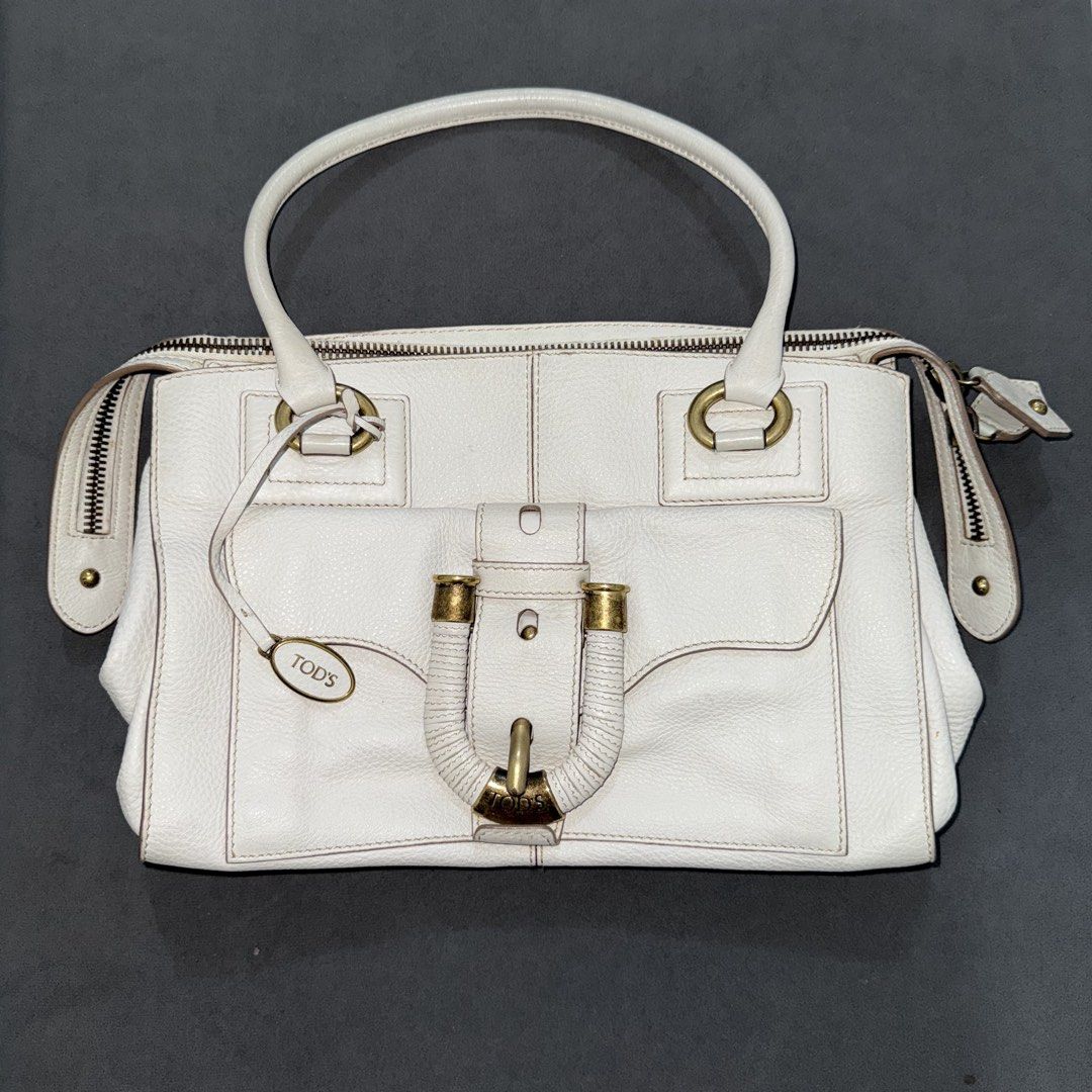Tods white leather handbag (Category: Luxury Bags & Wallets) located in Calasiao. Submitted by jafaith_man (Listing ID 1469710997, Image 1). Description: Authentic Vintage Tod’s White Leather Front Pocket Satchel, an iconic design from the Italian luxury house known for its structured craftsmanship and premium materials. The exact design features a distinctively woven or wrapped vertical strap running down the front flap pocket, accented by a gol