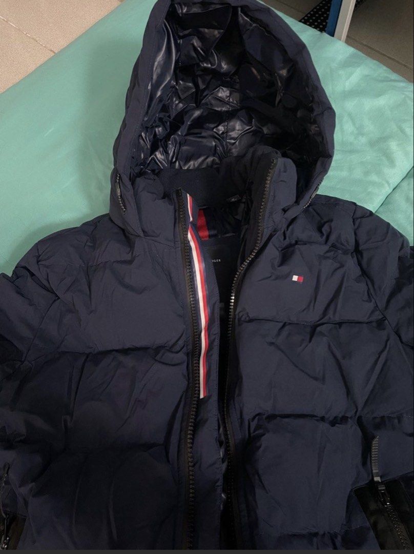 Tommy Hilfiger Navy Blue Puffer Jacket Size M (Category: Coats, Jackets and Outerwear) located in Las Pinas. Submitted by nickelcloset (Listing ID 1469601173, Image 2). Description: - Brand: Tommy Hilfiger - Style: Stretch down jacket - Color: Navy blue - Size: Medium - Condition: Excellent (worn once on a winter trip) - Features: Wind-resistant, warm insulated build, full zip front with signature red, white, and blue interior trim, attached hood