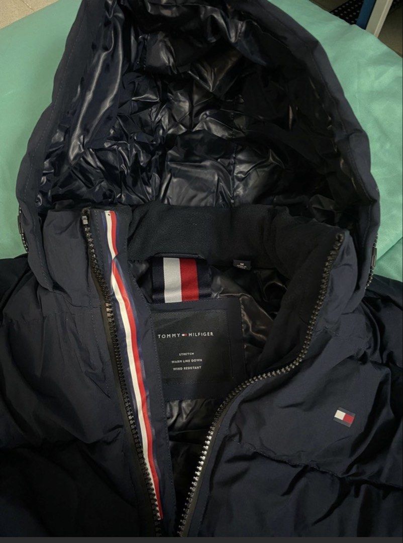 Tommy Hilfiger Navy Blue Puffer Jacket Size M (Category: Coats, Jackets and Outerwear) located in Las Pinas. Submitted by nickelcloset (Listing ID 1469601173, Image 3). Description: - Brand: Tommy Hilfiger - Style: Stretch down jacket - Color: Navy blue - Size: Medium - Condition: Excellent (worn once on a winter trip) - Features: Wind-resistant, warm insulated build, full zip front with signature red, white, and blue interior trim, attached hood