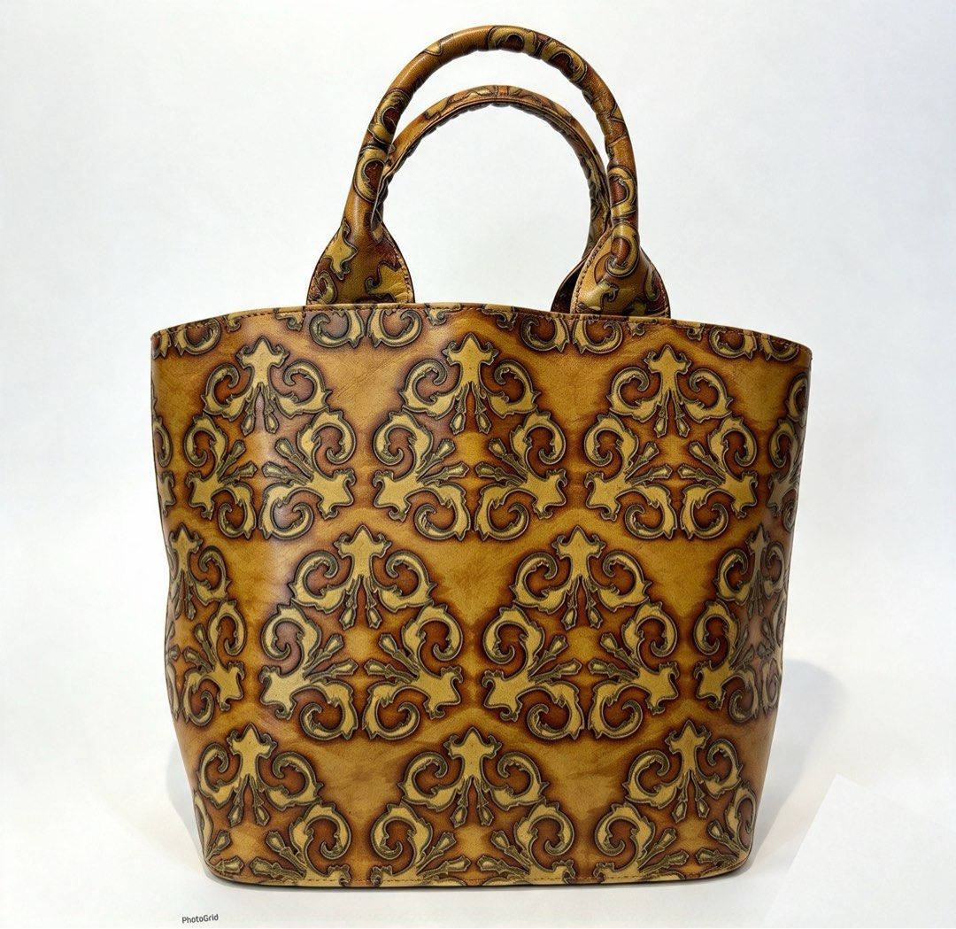 TOOLED Vintage patterned leather tote bag with double handles (Category: Tote Bags) located in Manila. Submitted by originalvintagebagph (Listing ID 1469697019, Image 1). Description: - Elegant brown and gold embossed leather tote with a detailed damask/scroll pattern - Dual rolled leather top handles for comfortable carrying - Clean brown fabric lining with a convenient zipped middle divider compartment - Sturdy structure that holds its shape we