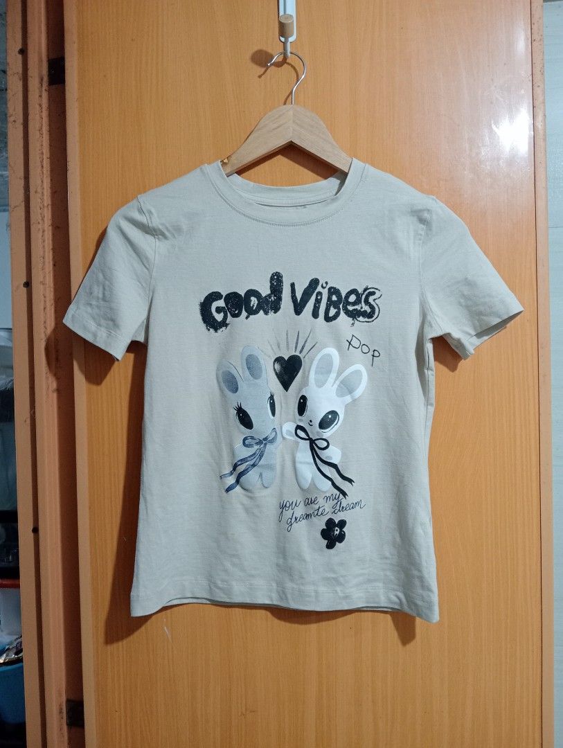 TopTen Good Vibes Graphic Tee (Category: Tshirts & Polo Shirts ) located in Quezon City. Submitted by niceoutfits (Listing ID 1469715018, Image 1). Description: - Brand: Original branding with retail tags still attached - Condition: Brand new, never worn - Design: Fun 'Good Vibes' graphic with cute cartoon bunnies and heart motifs - Color: Grey - Fit: Crew neck, casual everyday fit - Material: Lightweight cotton for all-day comfort.