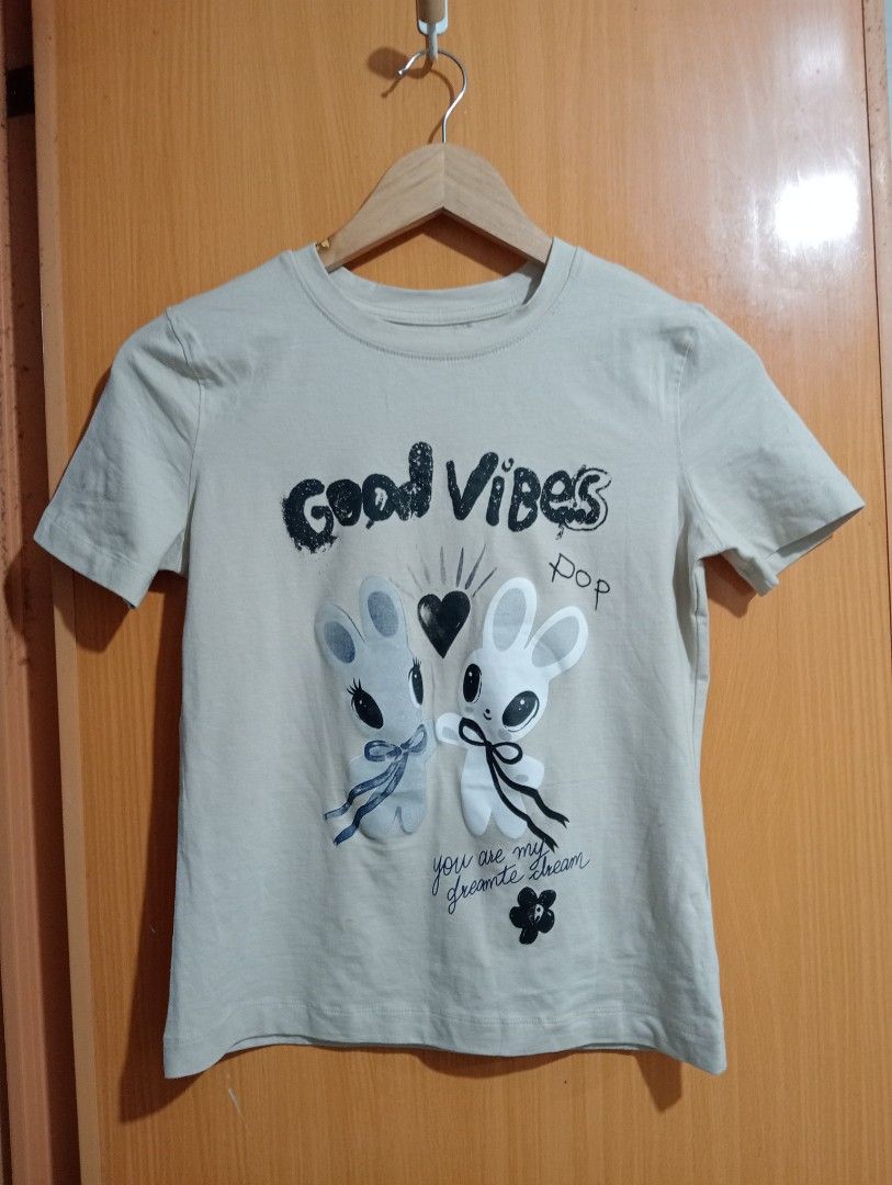 TopTen Good Vibes Graphic Tee (Category: Tshirts & Polo Shirts ) located in Quezon City. Submitted by niceoutfits (Listing ID 1469715018, Image 2). Description: - Brand: Original branding with retail tags still attached - Condition: Brand new, never worn - Design: Fun 'Good Vibes' graphic with cute cartoon bunnies and heart motifs - Color: Grey - Fit: Crew neck, casual everyday fit - Material: Lightweight cotton for all-day comfort.