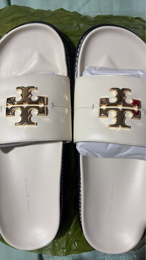 Tory Burch Anatomic Lug Slides (Category: Flats & Sandals) located in Manila. Submitted by libienbien (Listing ID 1469701278, Image 2). Description: - Brand: Tory Burch - Style: White leather slide sandals with gold-tone T logo hardware - Size: US 8 (stamped on sole) - Features: Contoured footbed with molded branding and black ridged rubber outsole - Condition: Includes original paper stuffing inside the straps for shape retention.