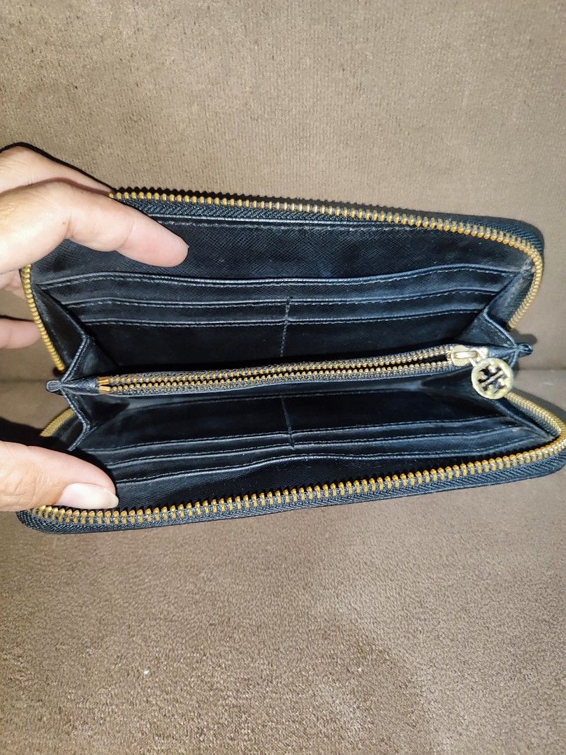 Tory Burch Black Saffiano Leather Zip Around Wallet (Category: Luxury Bags & Wallets) located in Paniqui. Submitted by arlenepari29210 (Listing ID 1469709577, Image 2). Description: - Brand: Tory Burch - Material: Premium black Saffiano leather - Hardware: Elegant gold-tone with iconic front logo emblem - Closure: Smooth zip-around closure - Interior: Multiple card slots, slip compartments, and a central zippered coin pocket - Size: Standard long