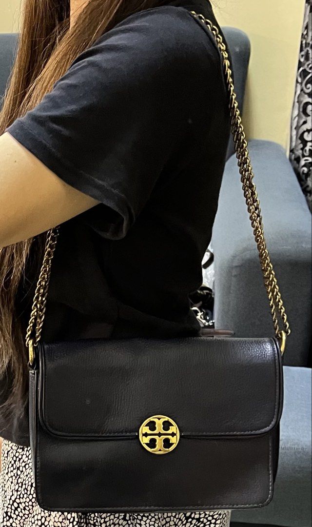 Tory Burch Blue Leather Shoulder Bag (Category: Shoulder Bags) located in Manila. Submitted by colineb (Listing ID 1469669466, Image 1). Description: - Brand: Tory Burch - Color: Navy Blue - Material: Textured leather with gold-tone hardware - Strap: Gold chain strap - Closure: Classic front logo clasp - Interior: Multiple compartments with a zippered pocket and brand logo patch - Lining: Clean monogram-printed fabric.