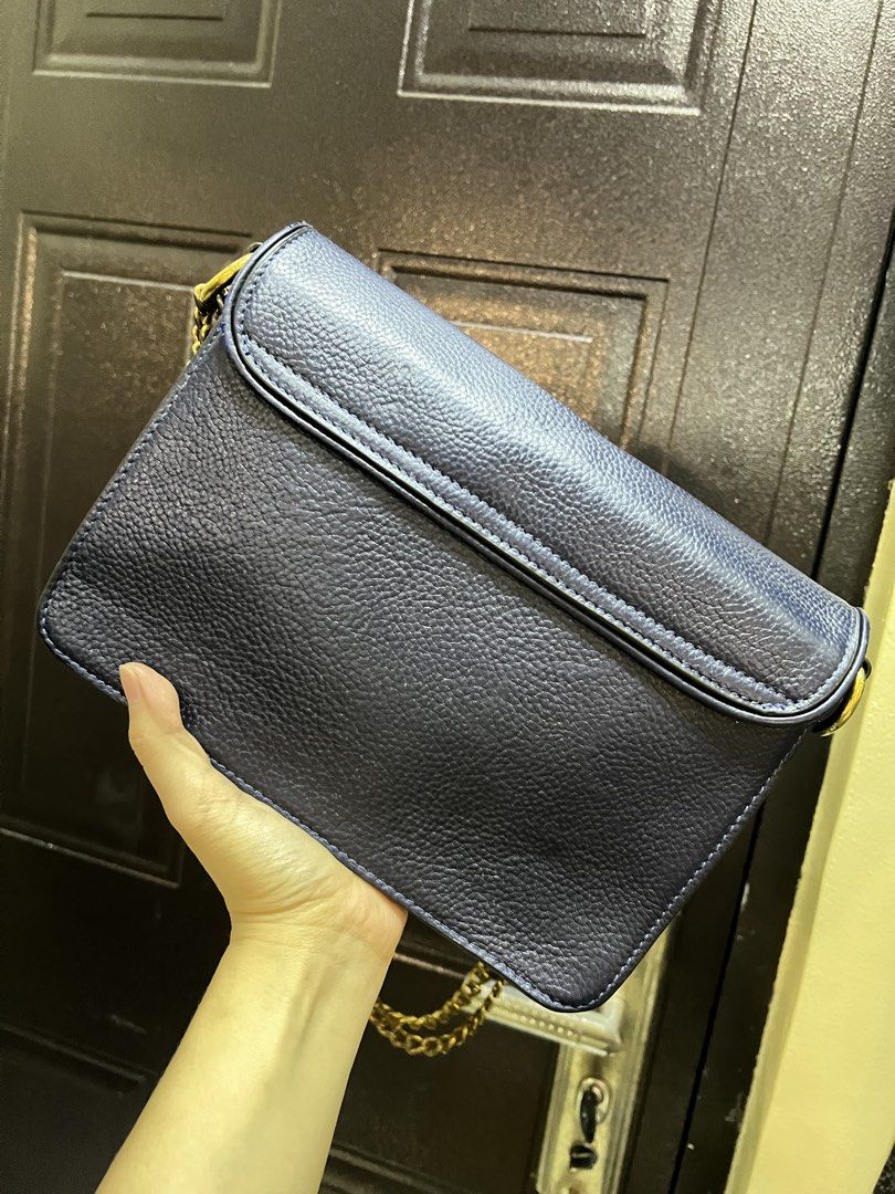 Tory Burch Blue Leather Shoulder Bag (Category: Shoulder Bags) located in Manila. Submitted by colineb (Listing ID 1469669466, Image 3). Description: - Brand: Tory Burch - Color: Navy Blue - Material: Textured leather with gold-tone hardware - Strap: Gold chain strap - Closure: Classic front logo clasp - Interior: Multiple compartments with a zippered pocket and brand logo patch - Lining: Clean monogram-printed fabric.