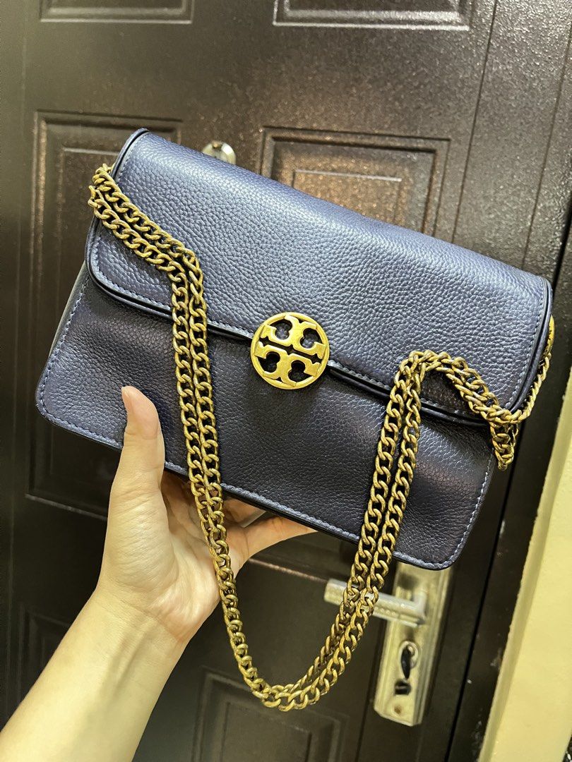 Tory Burch Blue Leather Shoulder Bag (Category: Shoulder Bags) located in Manila. Submitted by colineb (Listing ID 1469669466, Image 2). Description: - Brand: Tory Burch - Color: Navy Blue - Material: Textured leather with gold-tone hardware - Strap: Gold chain strap - Closure: Classic front logo clasp - Interior: Multiple compartments with a zippered pocket and brand logo patch - Lining: Clean monogram-printed fabric.