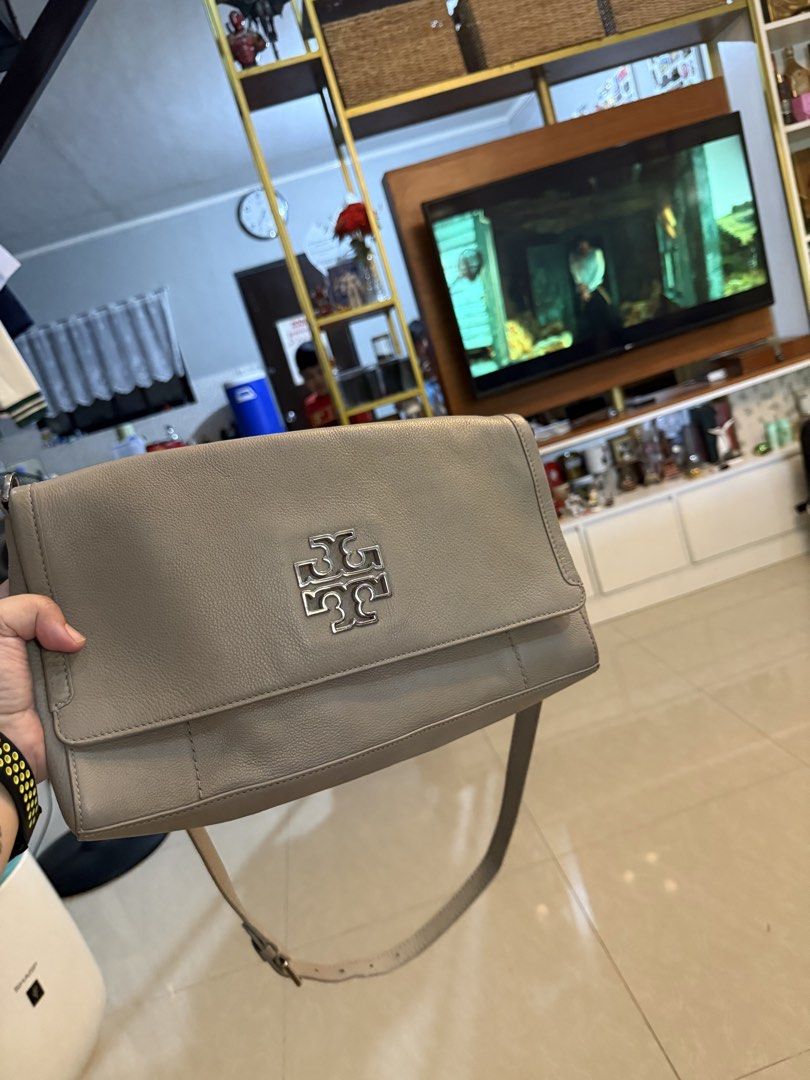 Tory Burch grey leather crossbody bag (Category: Luxury Bags & Wallets) located in Cavite. Submitted by shreemayc (Listing ID 1469599378, Image 2). Description: - Brand: Tory Burch - Style: Crossbody bag / shoulder bag - Color: Taupe grey - Material: Premium leather - Hardware: Silver-tone with big metal logo plaque on front flap - Design: Structured rectangular shape with clean stitching details - Strap: Long matching leather strap - Condition: 