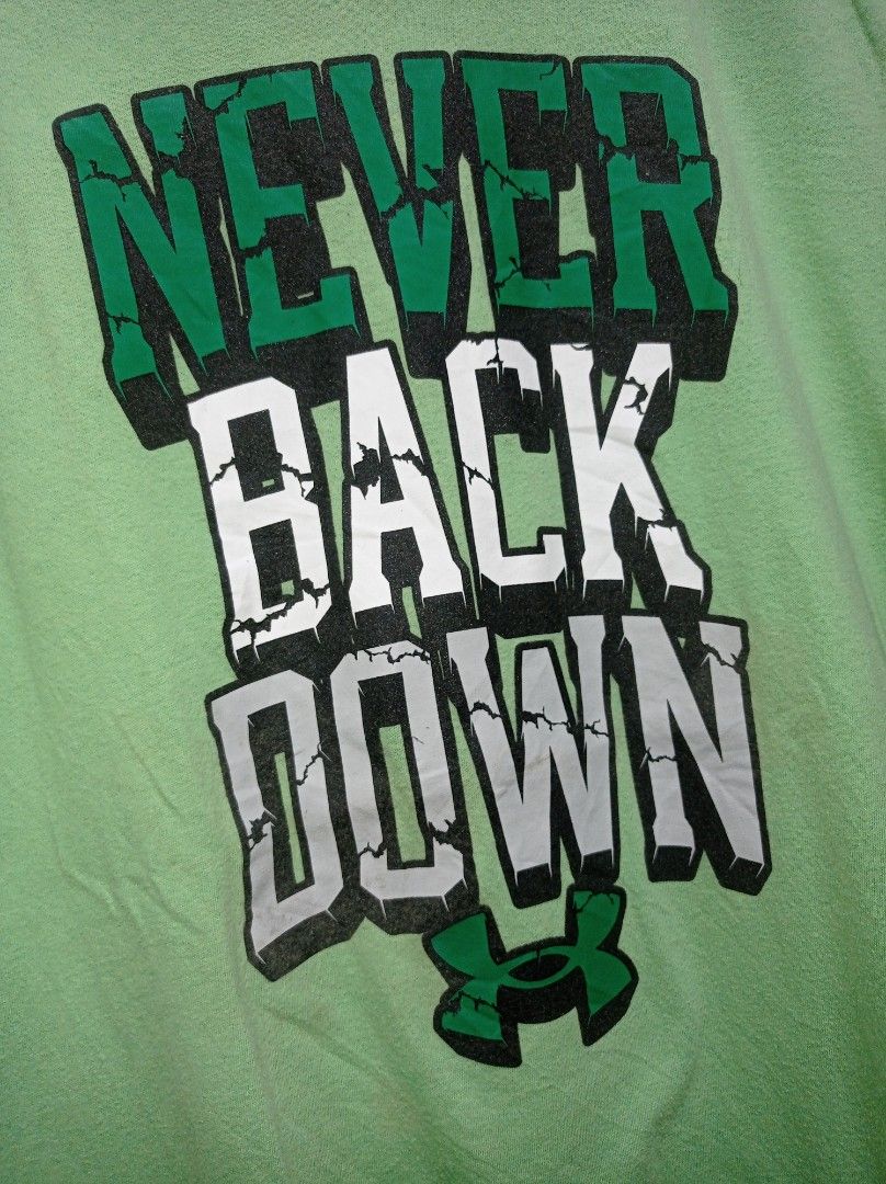 Under Armour "never back down" (Category: Tshirts & Polo Shirts ) located in Pasig City. Submitted by pureselectionapparel (Listing ID 1469748921, Image 3). Description: Under Armour "never back down" 🏷️ Size med-large Dimes: 21width 28.5length Very Good Condition Issue: Fine lints 300 plus ship Location: Pasig City.