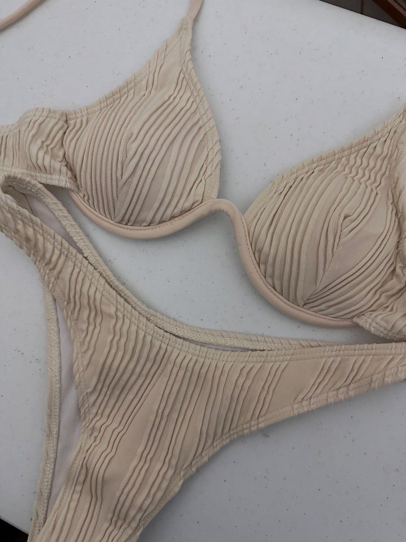 Underwire Bikini Set Cream (Category: Bikinis & Swimsuits) located in Pasig City. Submitted by prelovedbysco (Listing ID 1469590447, Image 2). Description: - Size: XS (fits 32-34A) - Color/Texture: Cream textured fabric - Top: Underwire cups, adjustable straps, and back clasp closure - Bottoms: Matching high-cut style - Lining: Fully lined inside Very secured. Worn this while surfing and cliff diving.
