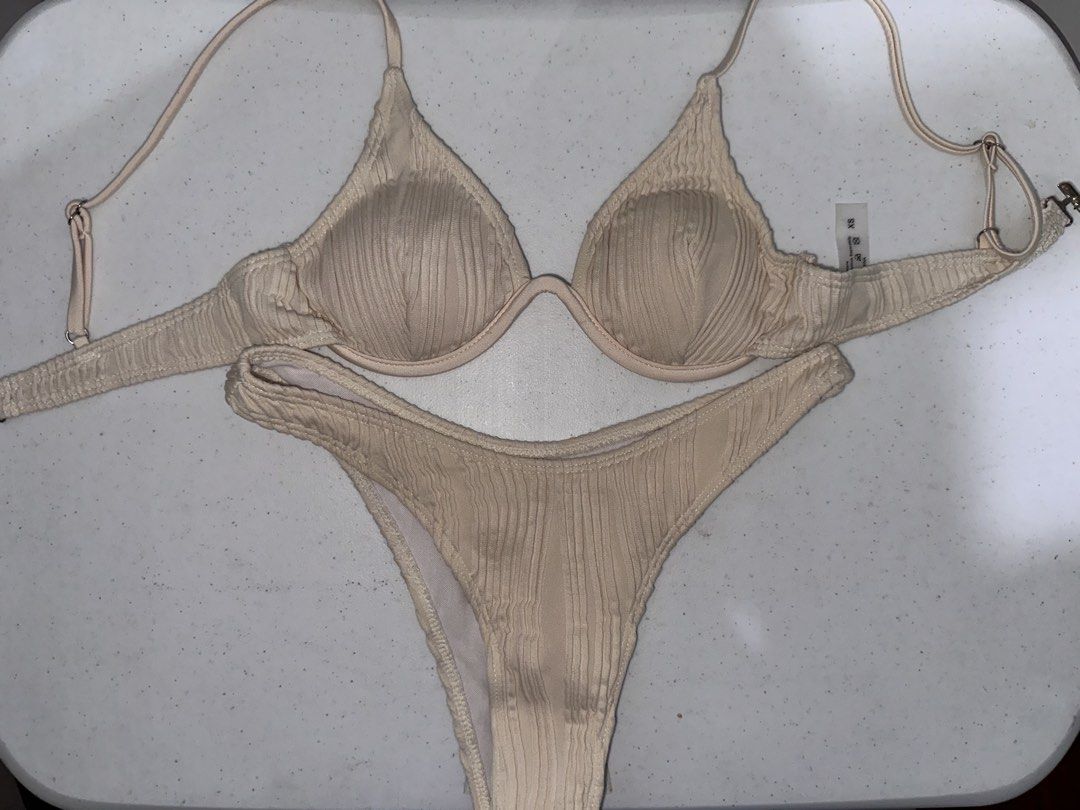 Underwire Bikini Set Cream (Category: Bikinis & Swimsuits) located in Pasig City. Submitted by prelovedbysco (Listing ID 1469590447, Image 3). Description: - Size: XS (fits 32-34A) - Color/Texture: Cream textured fabric - Top: Underwire cups, adjustable straps, and back clasp closure - Bottoms: Matching high-cut style - Lining: Fully lined inside Very secured. Worn this while surfing and cliff diving.