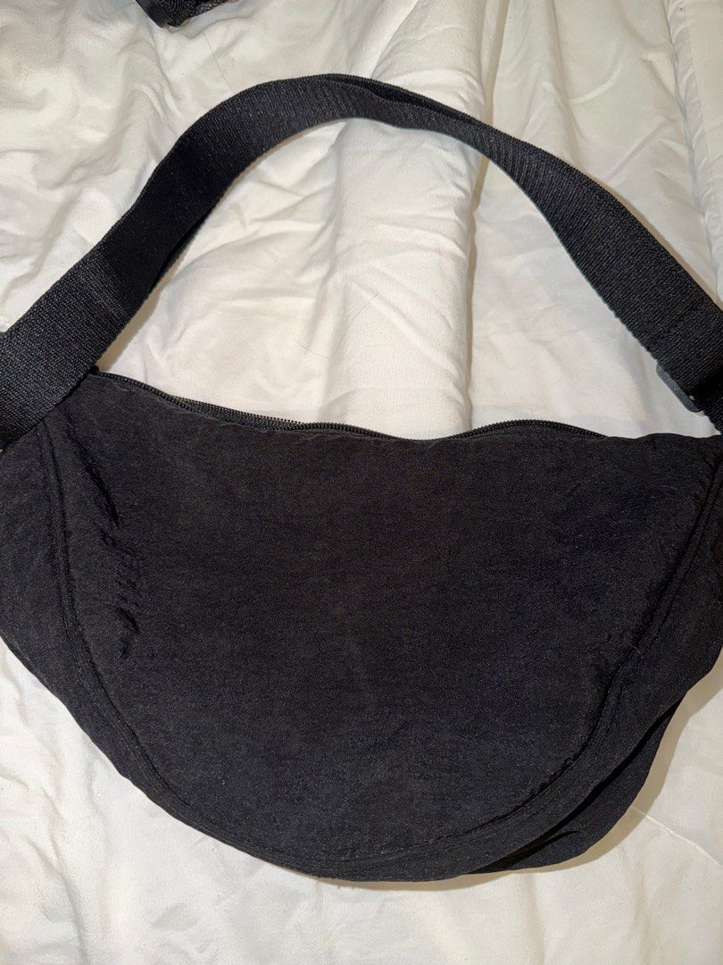 Uniqlo Dumpling Shoulder Bag Black (Category: Cross-body Bags) located in Las Pinas. Submitted by vashaina (Listing ID 1469711024, Image 1). Description: - Brand: Uniqlo - Color: Classic Black - Style: Dumpling mini shoulder bag / crescent shape - Material: Durable nylon with secure zipper closure - Features: Adjustable strap and handy interior slip pockets for easy organization - Use: Lightweight and very versatile daily carryall - AUTHENTIC .