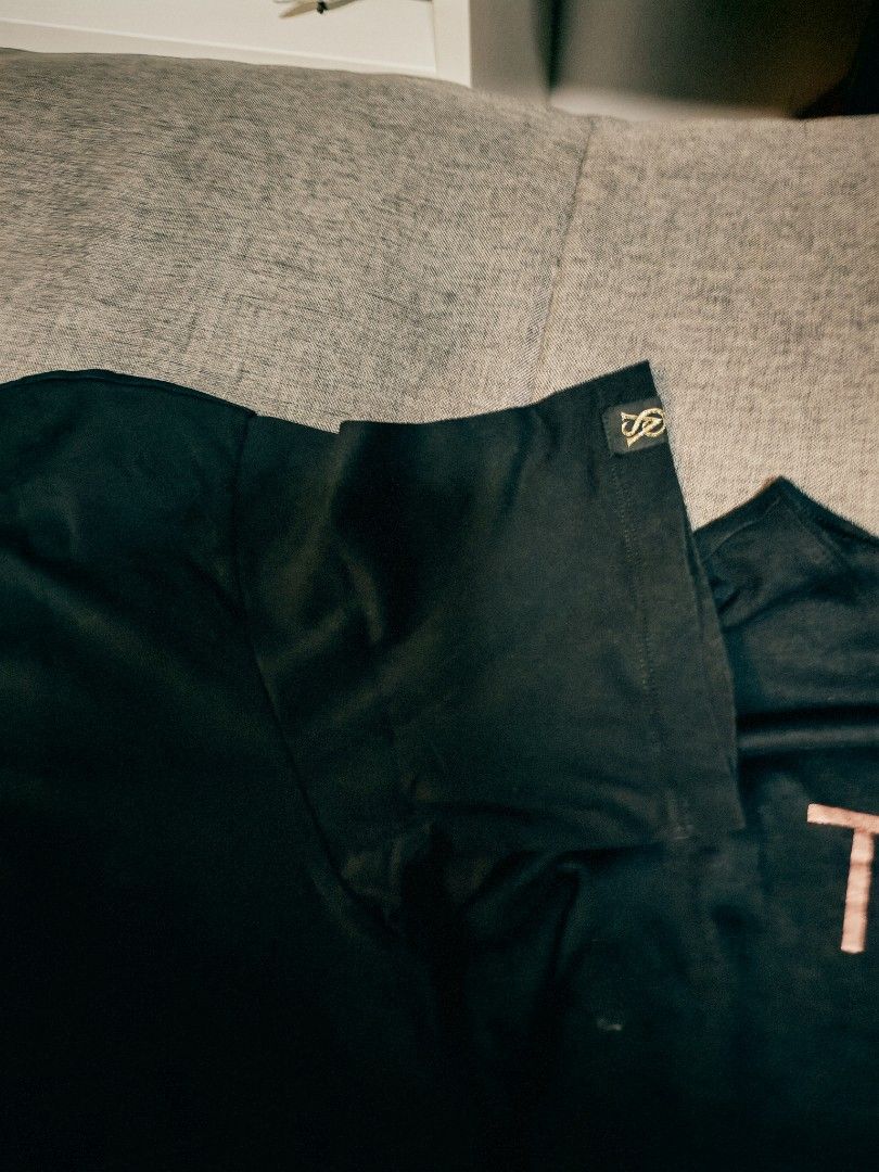 Victoria's Secret Tease Black Tee (Category: Shirts) located in Makati City. Submitted by momsieapril (Listing ID 1469656000, Image 2). Description: - Brand: Victoria's Secret - Color: Black with rose gold 'TEASE' chest graphic - Size: Large (Relaxed fit) - Material: Super soft 100% cotton - Details: Features small VS logo patch on the left sleeve and round neckline - Condition: Great casual top for everyday wear or cozy lounging - Mode of Paymen