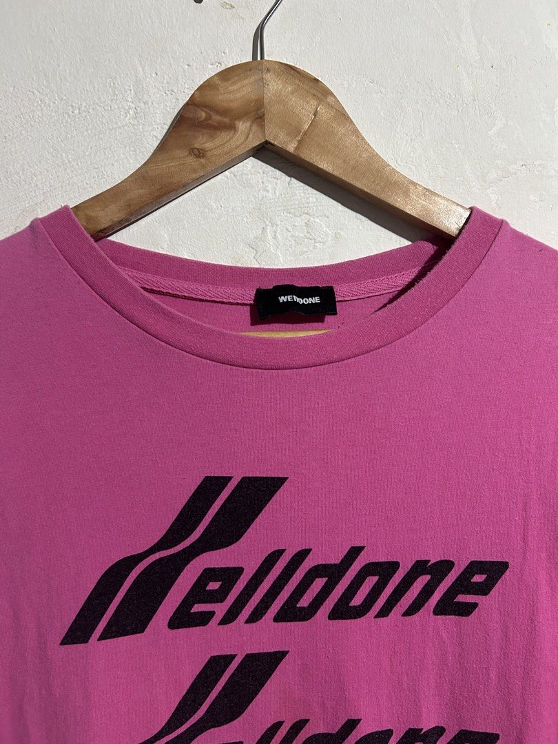 We11done Pink Repeated Logo T-Shirt (Category: Shirts) located in Manila. Submitted by romnick907 (Listing ID 1469705720, Image 2). Description: Vibrant pink cotton tee from We11done. Bold black repeated logo print running down the front chest. Crew neck collar, short sleeves, standard straight hem. Interior black neck label with white branding. Side care and composition tags attached near the hem. Relaxed boxy streetwear fit..