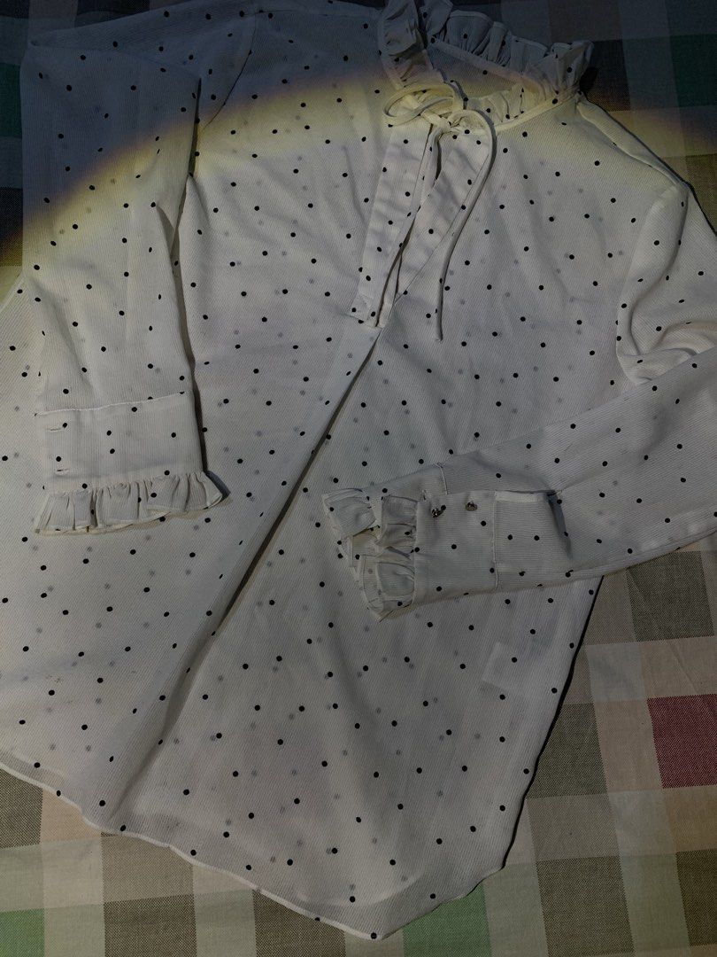 White Polka Dot Long Sleeve Blouse with Ruffles (Category: Blouses) located in Rizal. Submitted by pcesspscl145 (Listing ID 1469707521, Image 3). Description: - Color/Pattern: White with all-over black polka dots - Design: High ruffled collar with front tie closure - Sleeves: Long sleeves with buttoned cuffs and ruffled wrist details - Fabric: Lightweight with a subtle vertical ribbed texture - Fit: Curved hemline, easy to style for office or cas