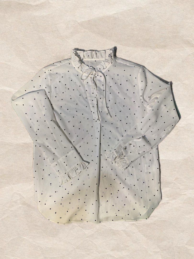 White Polka Dot Long Sleeve Blouse with Ruffles (Category: Blouses) located in Rizal. Submitted by pcesspscl145 (Listing ID 1469707521, Image 1). Description: - Color/Pattern: White with all-over black polka dots - Design: High ruffled collar with front tie closure - Sleeves: Long sleeves with buttoned cuffs and ruffled wrist details - Fabric: Lightweight with a subtle vertical ribbed texture - Fit: Curved hemline, easy to style for office or cas