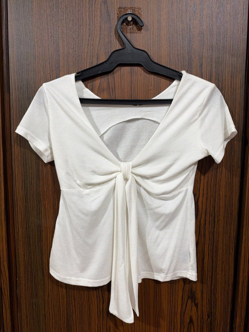 White Short Sleeve Top with Front Tie Detail (Category: Blouses) located in Quezon City. Submitted by co.coph (Listing ID 1469710797, Image 1). Description: - Color: White - Style: Short sleeve top with deep V-neckline - Design: Trendy front tied knot with long hanging fabric tails - Material: Textured knit - Fit: Standard hemline hitting around the hips - Condition: Excellent, clean with no stains or damage - Status: Ready to wear.