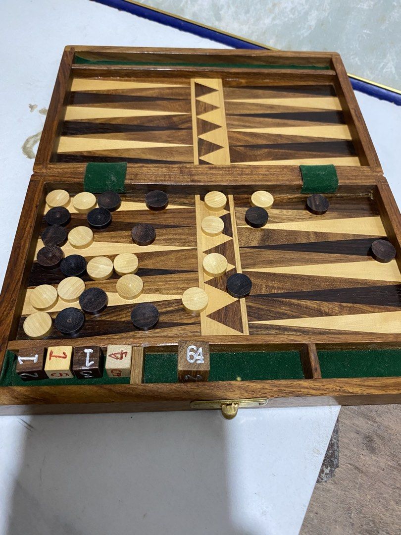 Wooden Backgammon Set Board Game with Dice and Chips (Category: Board Games & Puzzles) located in Calamba. Submitted by chebvintagedepot (Listing ID 1469664700, Image 1). Description: (B18-03) “Wooden folding backgammon board with decorative wood inlay and a traditional design. The board folds for storage and transport, making it suitable for home use or travel. Please note: Missing one white circular checker piece. The set is incomplete. (14/15 