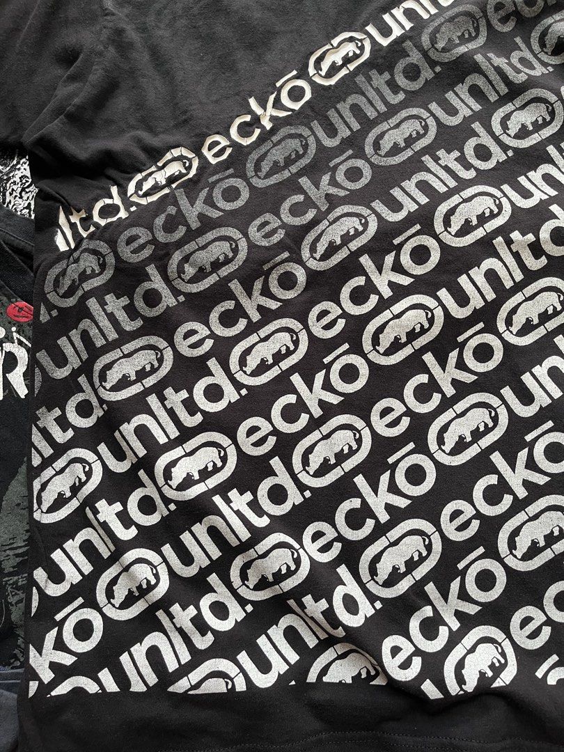 Y2K Ecko Unltd Black Graphic Tee with Rhino Logo (Category: Tshirts & Polo Shirts ) located in Baao. Submitted by plainclothesdept (Listing ID 1469706803, Image 3). Description: y2k ecko unltd logo spellout all over print width - 22 in. length - 28 in. no flaws - Brand: Ecko Unltd - Color: Black - Design: Diagonal repeat logo and iconic rhino graphics across the chest - Details: Crew neck, short sleeves, branded inner collar tag - Condition: Auth