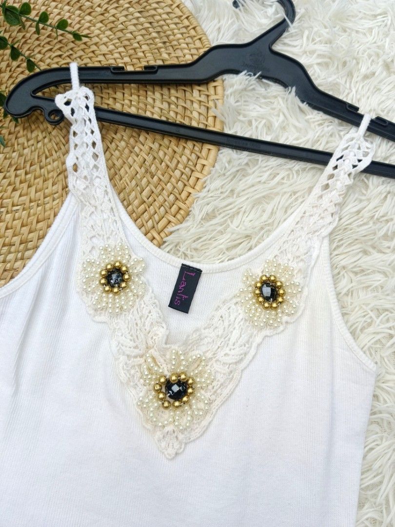Y2k White Camisole Sleeveles Top (Category: Sleeveless) located in Bayombong. Submitted by lovethrifting.slay (Listing ID 1469645789, Image 2). Description: Title: White Camisole Sleeveles Top Description: White camisole top featuring floral lace detailing and rhinestone or bead accents along the V-neckline. Size: S-M Condition: Likenew Flaws: none Price: Php180 Payment Method: Gcash Delivery Option: J&T (74sf shoulder by buyer).