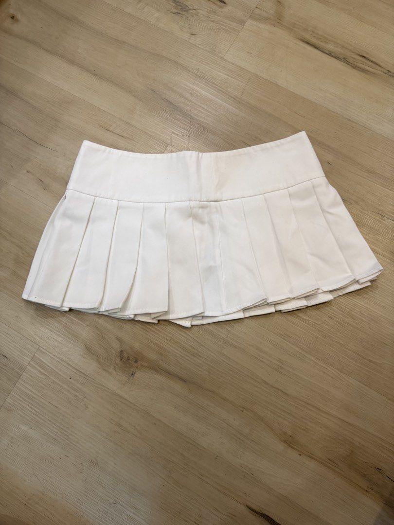 y2k white pleated mini skirt with buttons (Category: Skirts) located in Manila. Submitted by _____car0usell (Listing ID 1469685864, Image 2). Description: y2k tennis skirt, pleated all around structured waistband with 3 silver front buttons - has some faint stains near the front pleats (barely noticeable in person) - i actually never got to use this, i think the minimal stains are only due to storage and can easily be removed when washed.