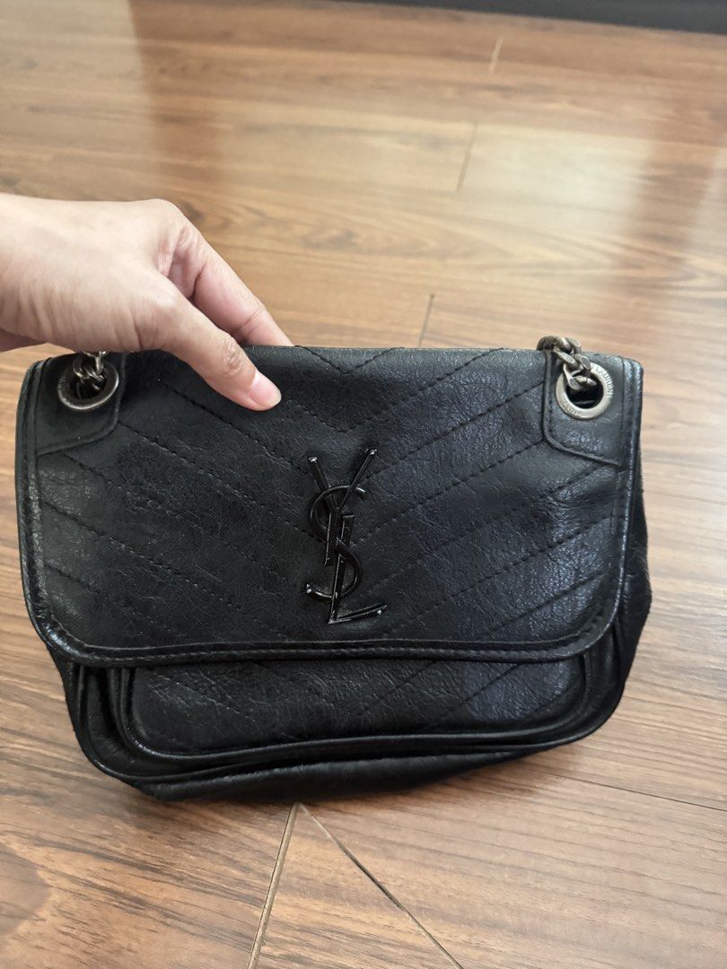 Y S L Niki (Category: Cross-body Bags) located in Rizal. Submitted by thrifty.mom (Listing ID 1469646826, Image 2). Description: - Brand: Saint Laurent - Material: Black crinkled leather with chevron quilting - Hardware: Dark hardware with signature YSL front monogram - Straps: Chain straps with leather shoulder guards and embossed logo - Capacity: Easily fits phone, keys, and wallet - perfect for daily use Thrift find item No guarantee no inclus