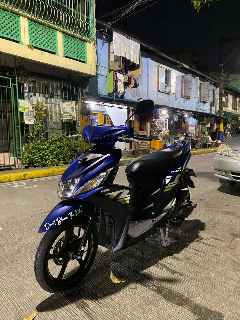 Yamaha Mio 125 Blue Scooter (Category: Motorbikes for Sale) located in Manila. Submitted by bravestorm_847932 (Listing ID 1469640213, Image 1). Description: Yamaha Mio 125 automatic scooter. Deep blue body panels with black accents and custom white decals. Black alloy wheels, single seat, and standard handlebars. Street parking background at night. Clean setup, ready to ride. Orig papers open Dos 2 valid Ids with 3signs license isa 1k Odo orig LT